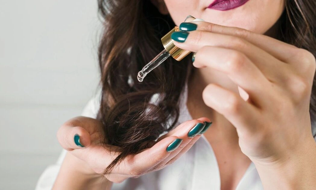 kobieta-aplikuje-sobie-olejek-na-koncowki-wlosow.webp