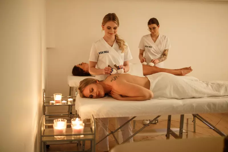 Studentki kosmetologii w WSKINOZ w trakcie wykonywania masażu tajskiego w ramach specjalizacji SPA&Wellness.webp