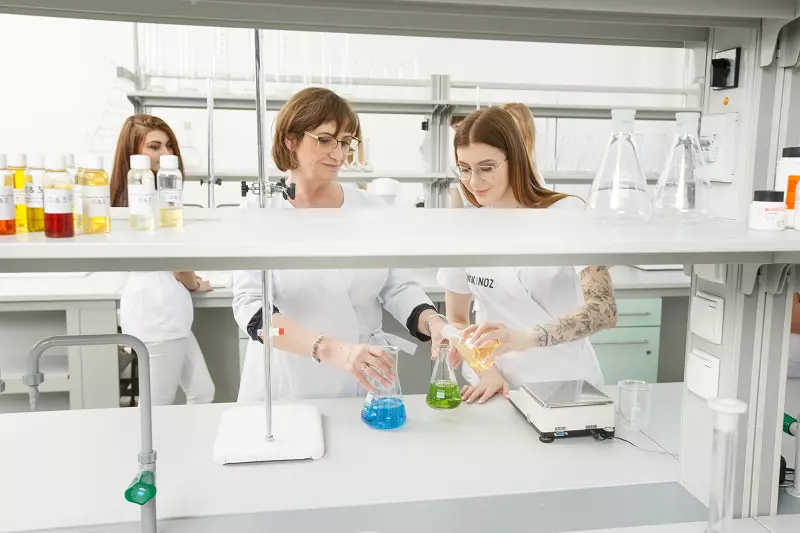 Rektor WSKINOZ, dr n. chem. Katarzyna Bujnicka w trakcie zajęć w laboratorium chemicznym pomaga studentce przygotować odpowiedni roztwór.