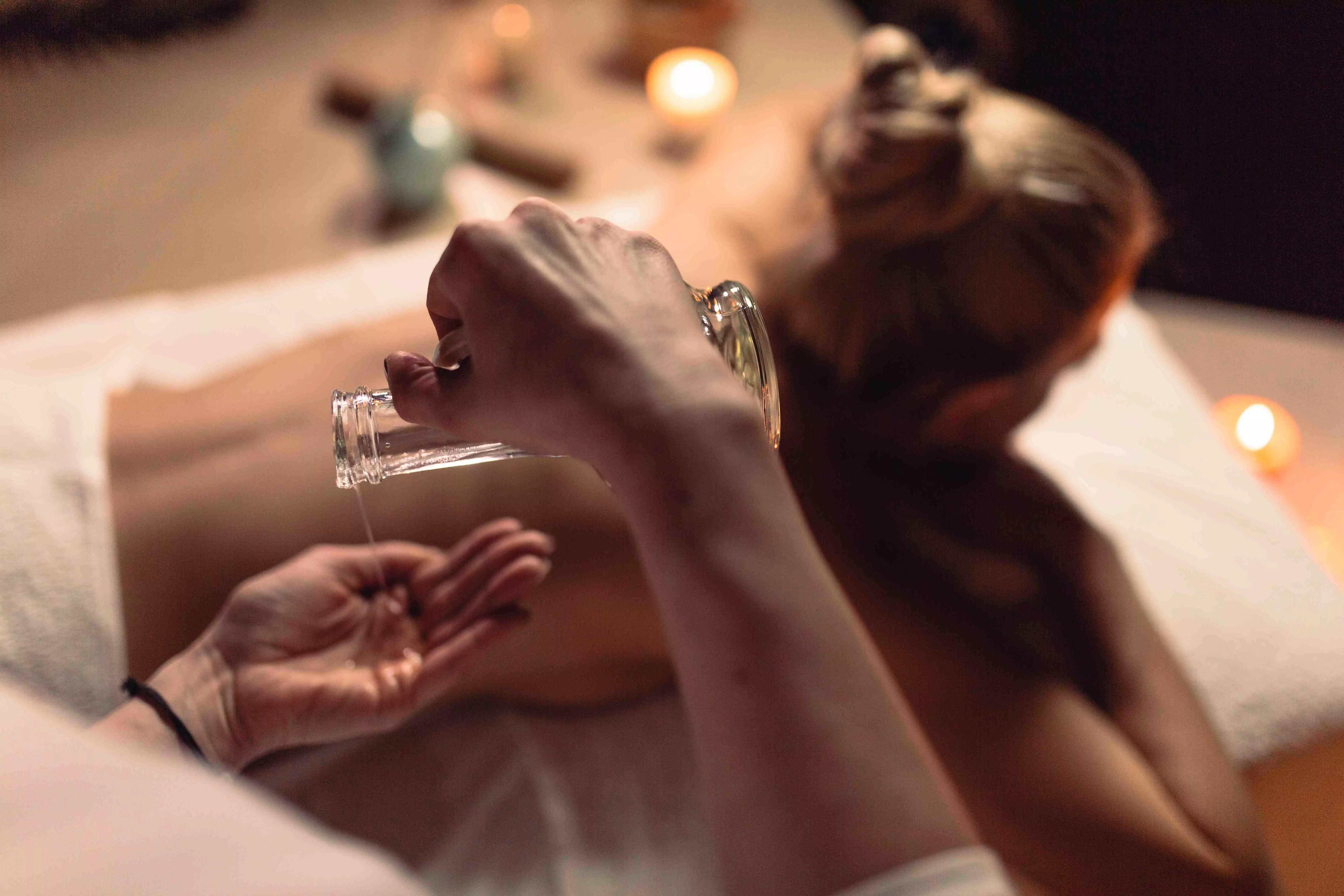Uczestnik kursu SPA&Wellness nakłada oliwę tuż przed wykonaniem masażu