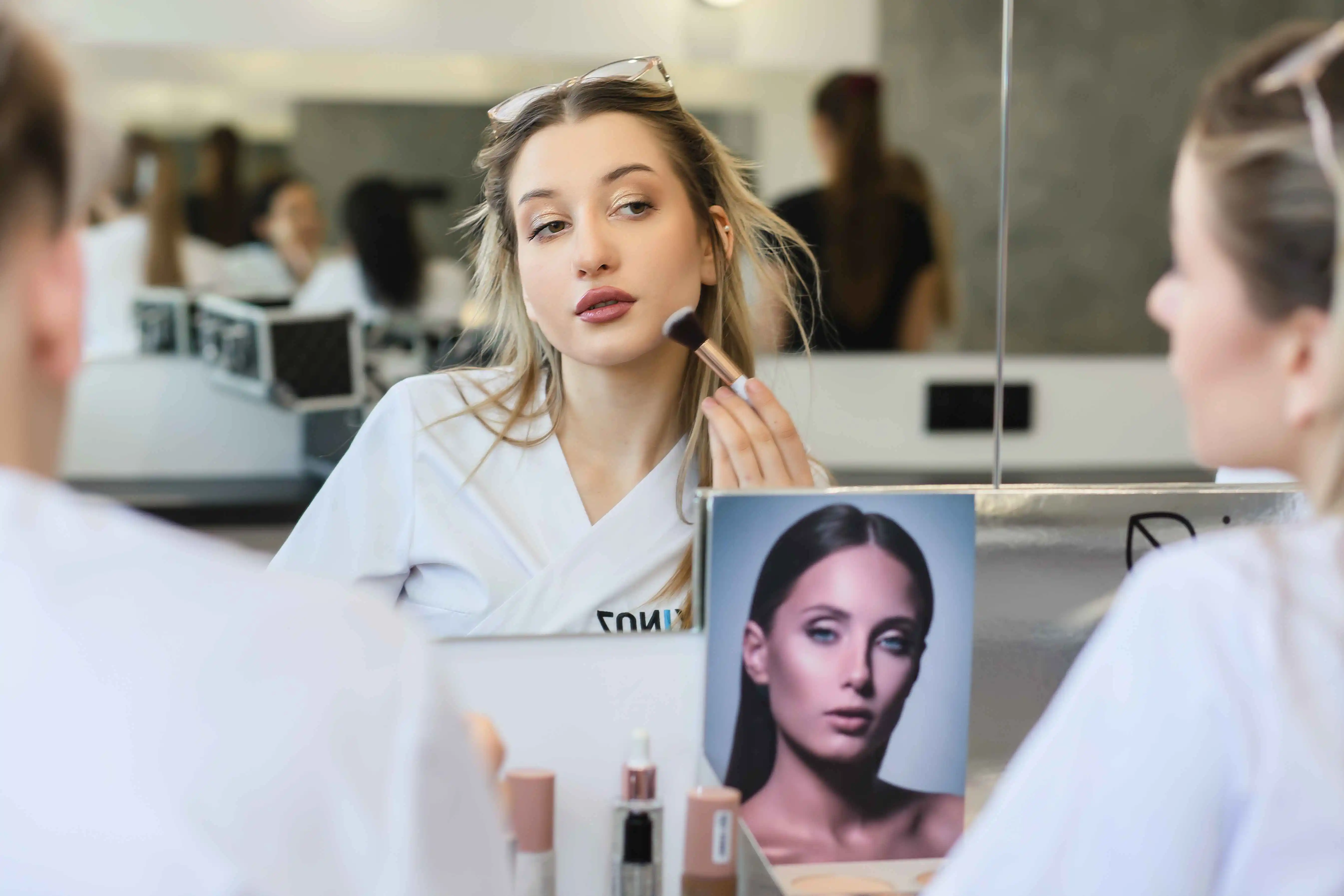 Studentka wykonuje makijaż w trakcie kursu wizażu i stylizacji w Wyższej Szkole Kosmetyki i Nauk o Zdrowiu 